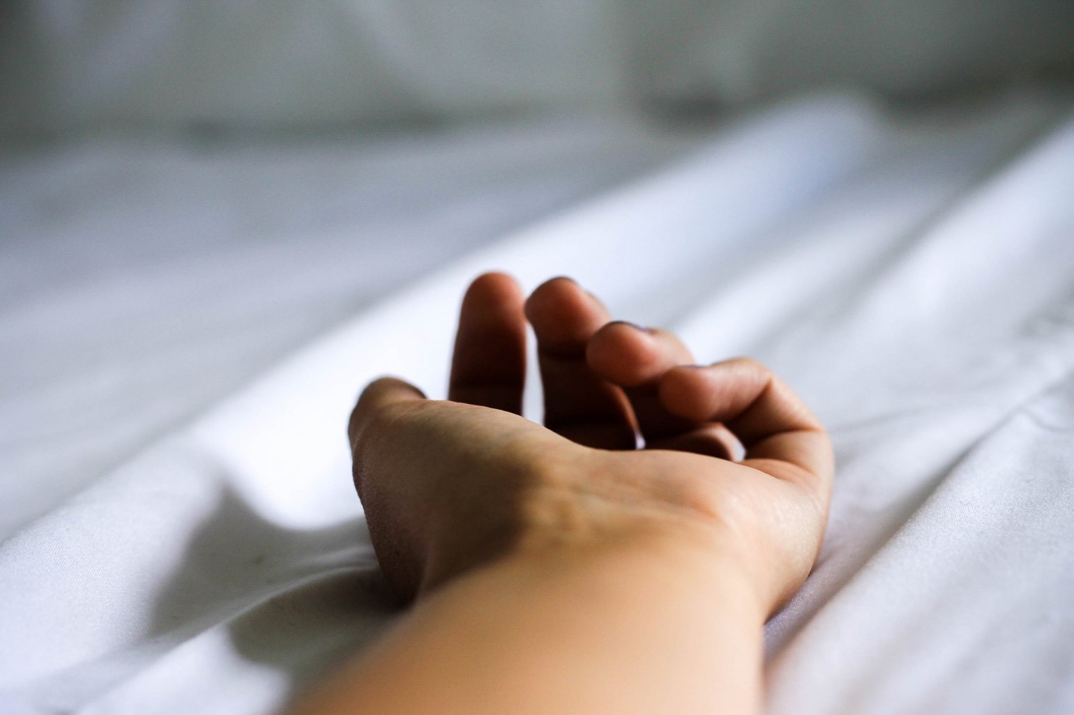 image of hand resting on a bed